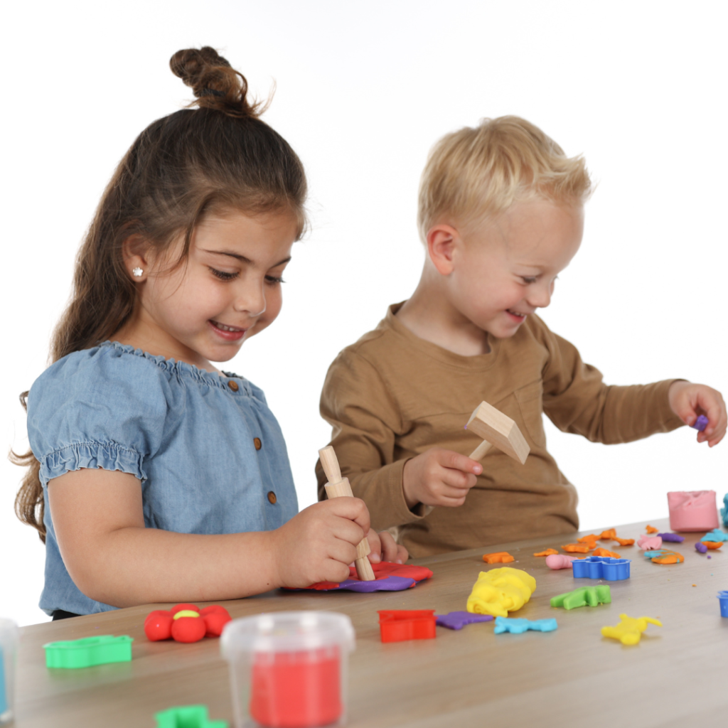 Twee kinderen aan tafel, spelend met klei van SES Creative. 